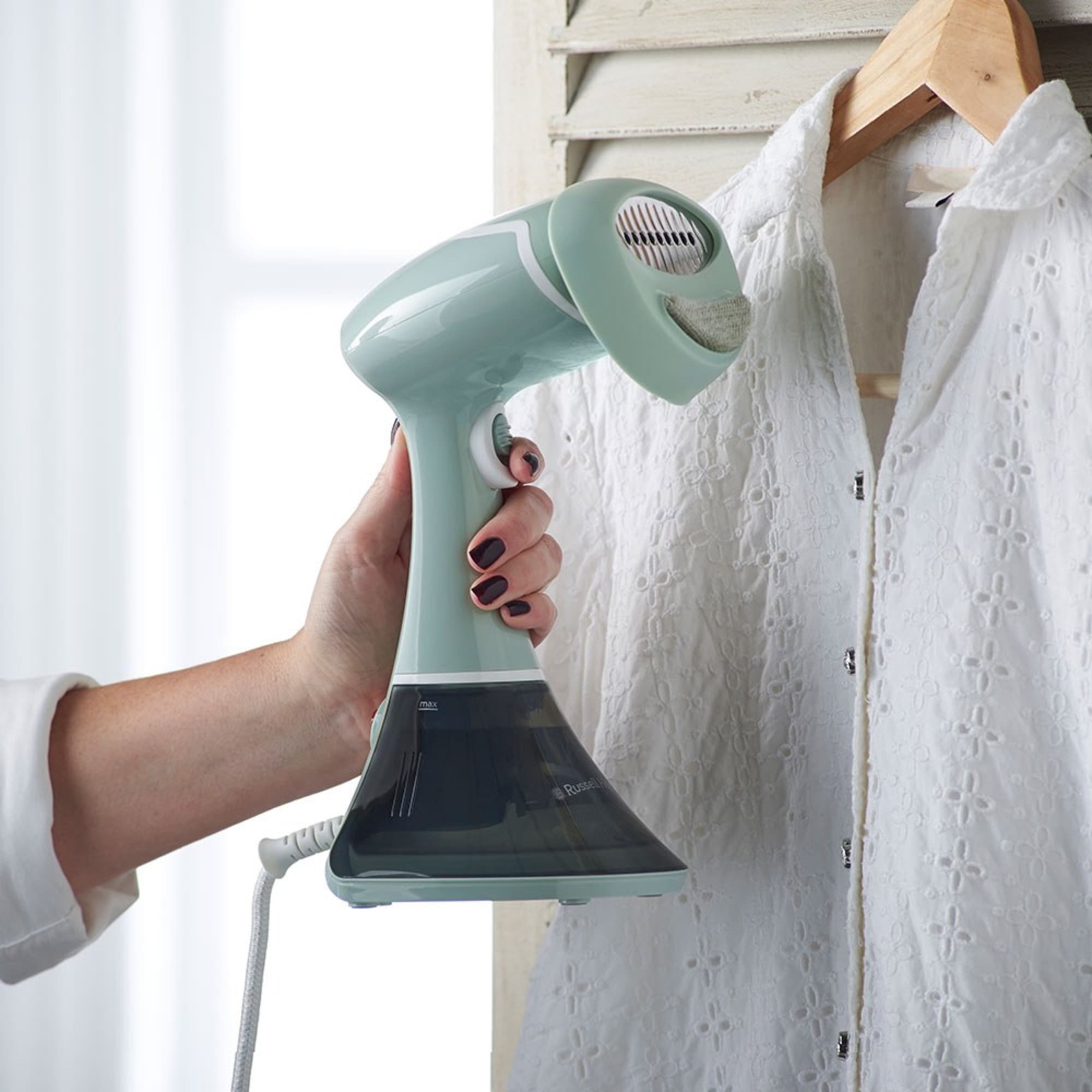 The steamer used on a shirt on a hanger