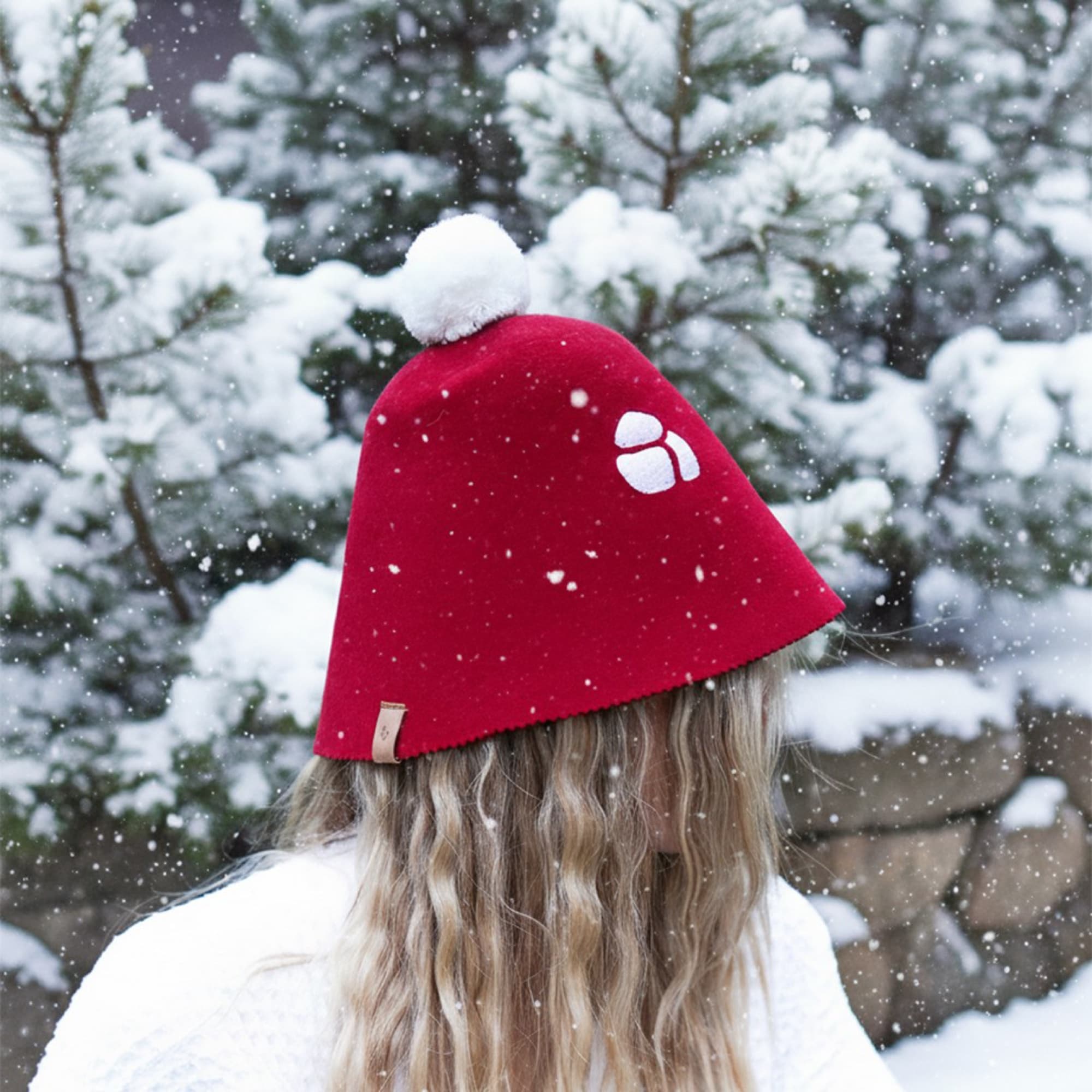 Red sauna hat in a snowy landscape
