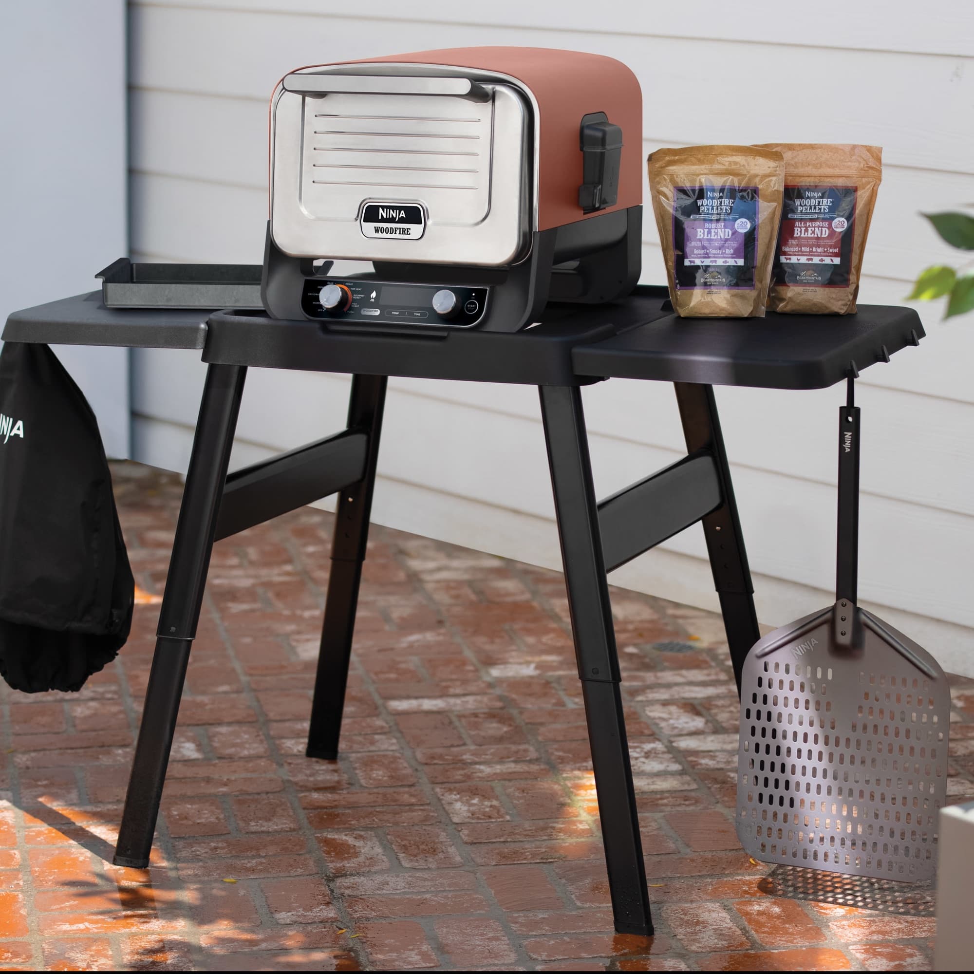 The Artisan pizza oven on the stand with hooks and side table