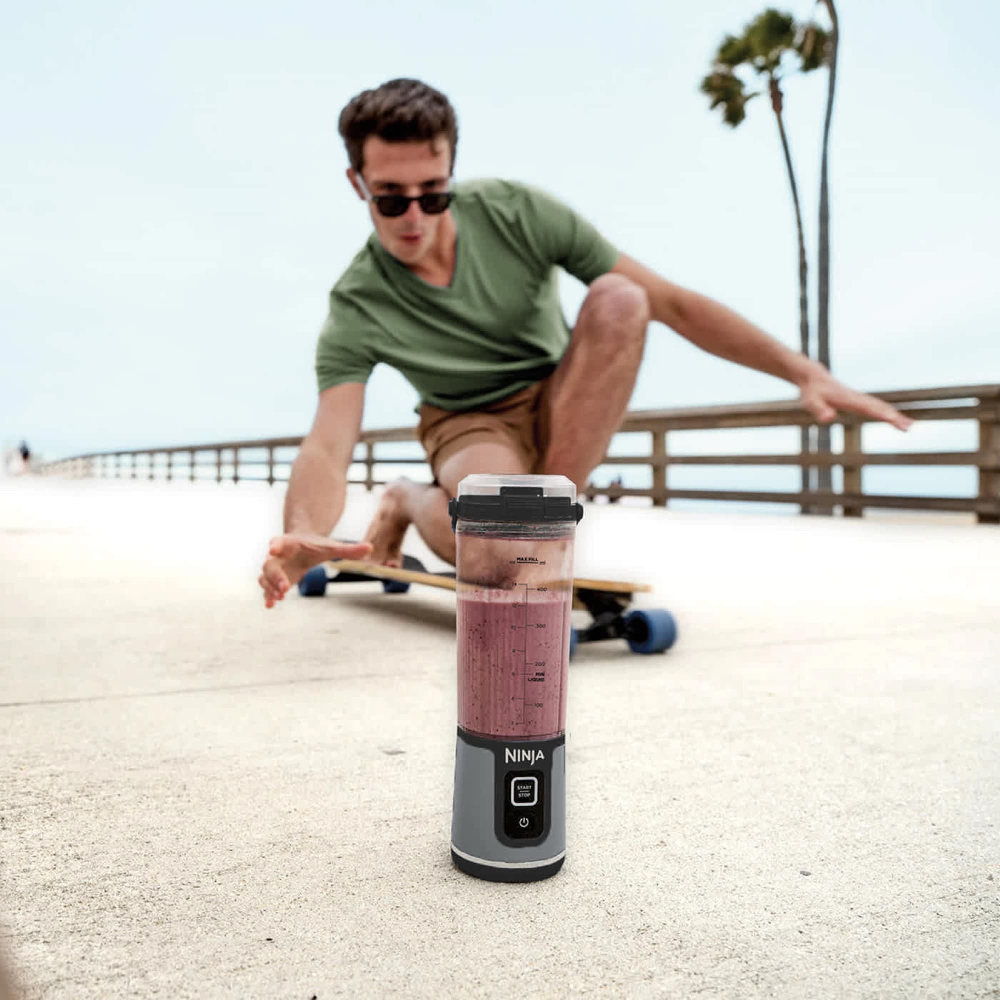 The blender with a smoothie on a seaside promenade