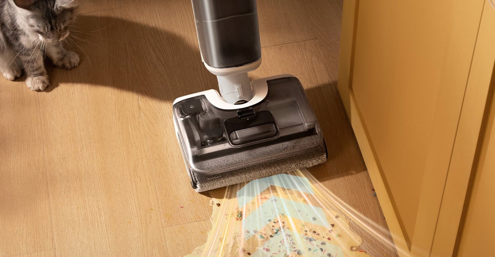 F25 GT picking up a spill on a wooden floor while the cat watches