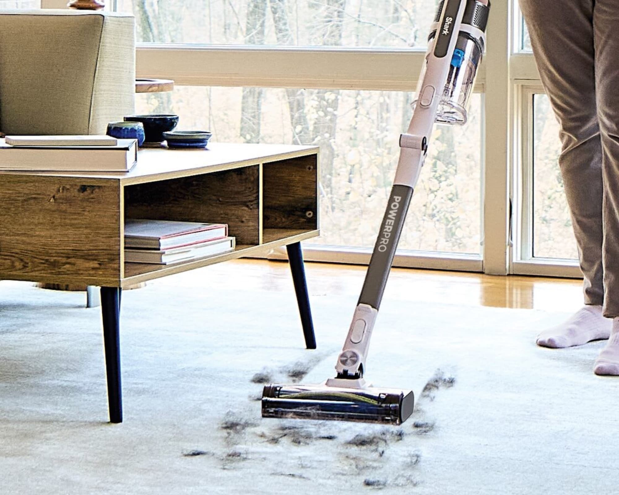 The vacuum picking up dirt from a living room rug