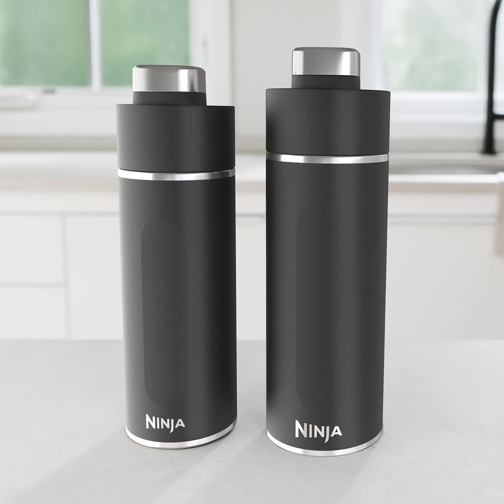 Two black bottles on the kitchen counter
