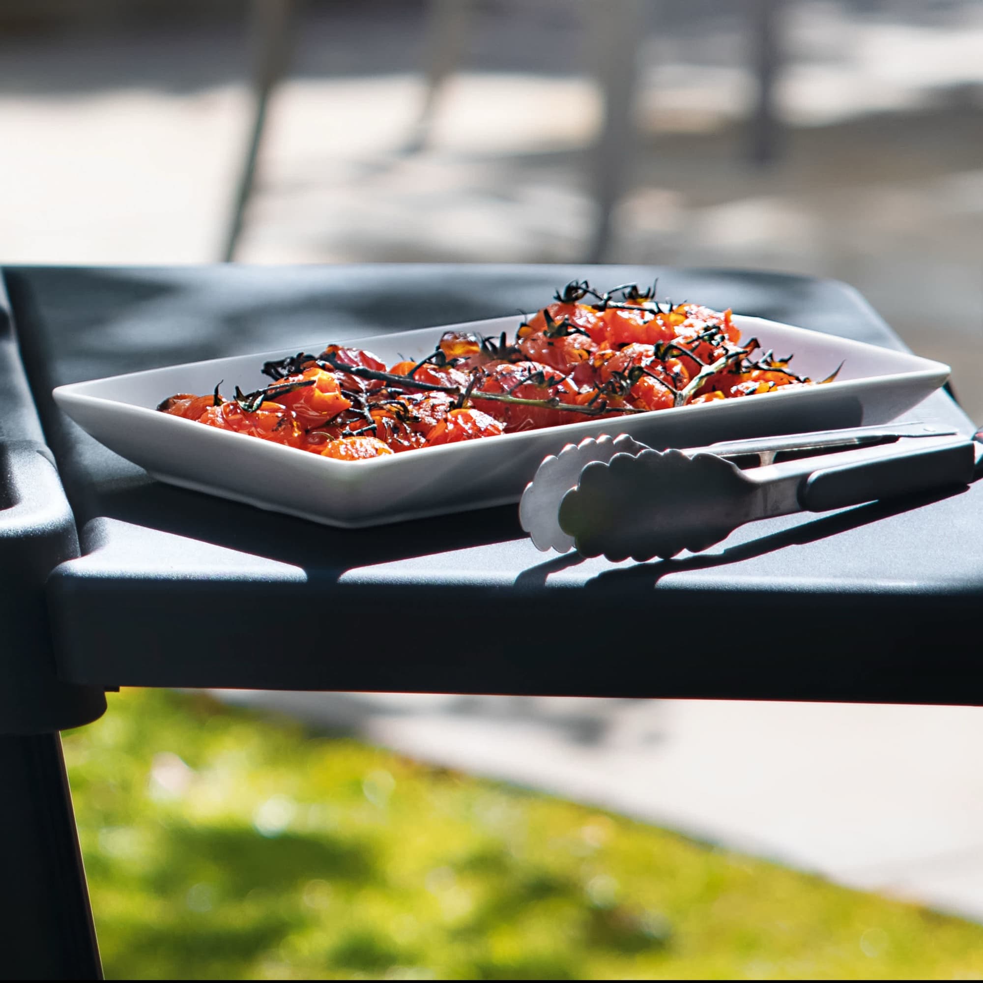 A platter of vegetables and tongs on the side table