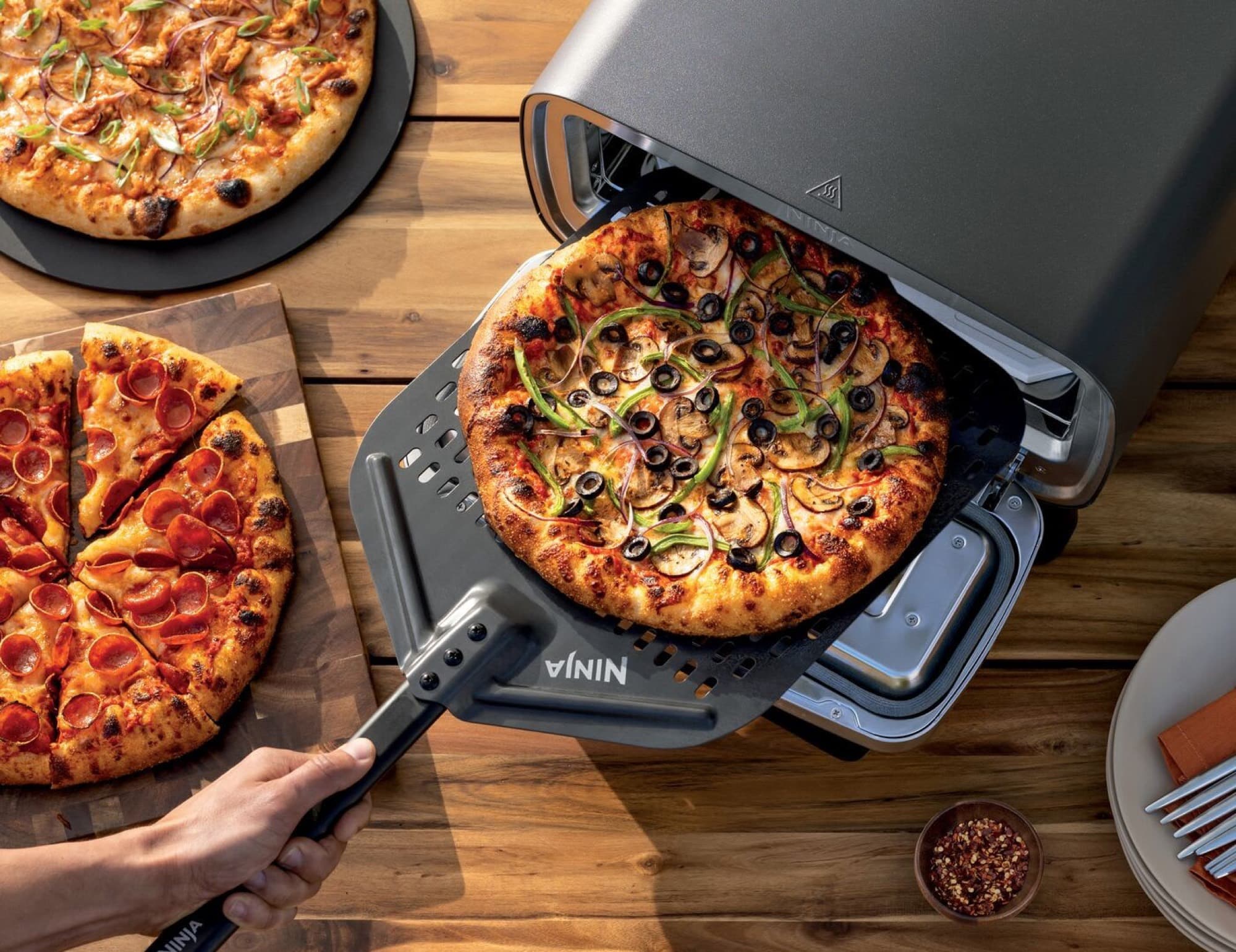 Pizzas on a peel and a wooden table