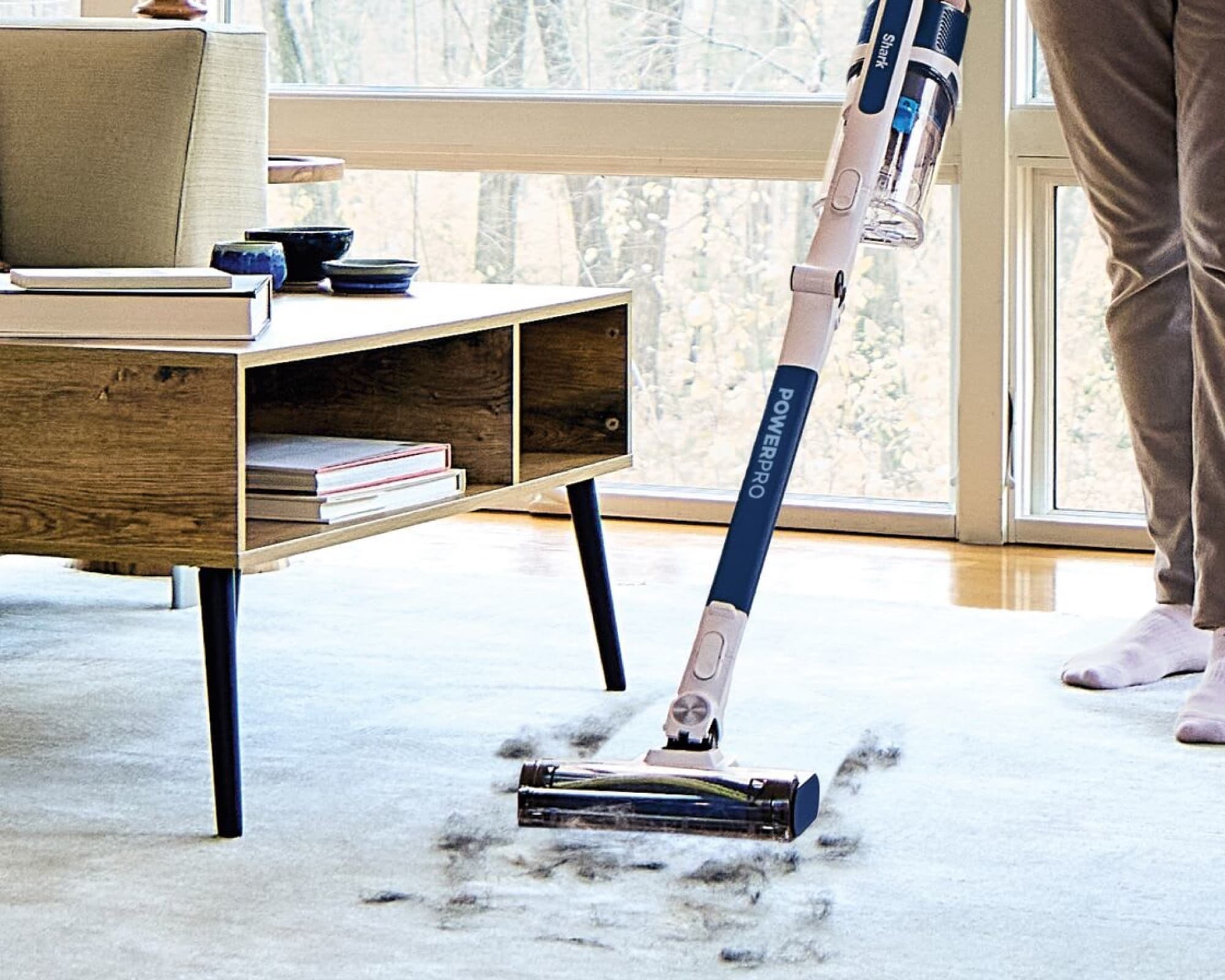 The vacuum picking up dirt from a living room rug