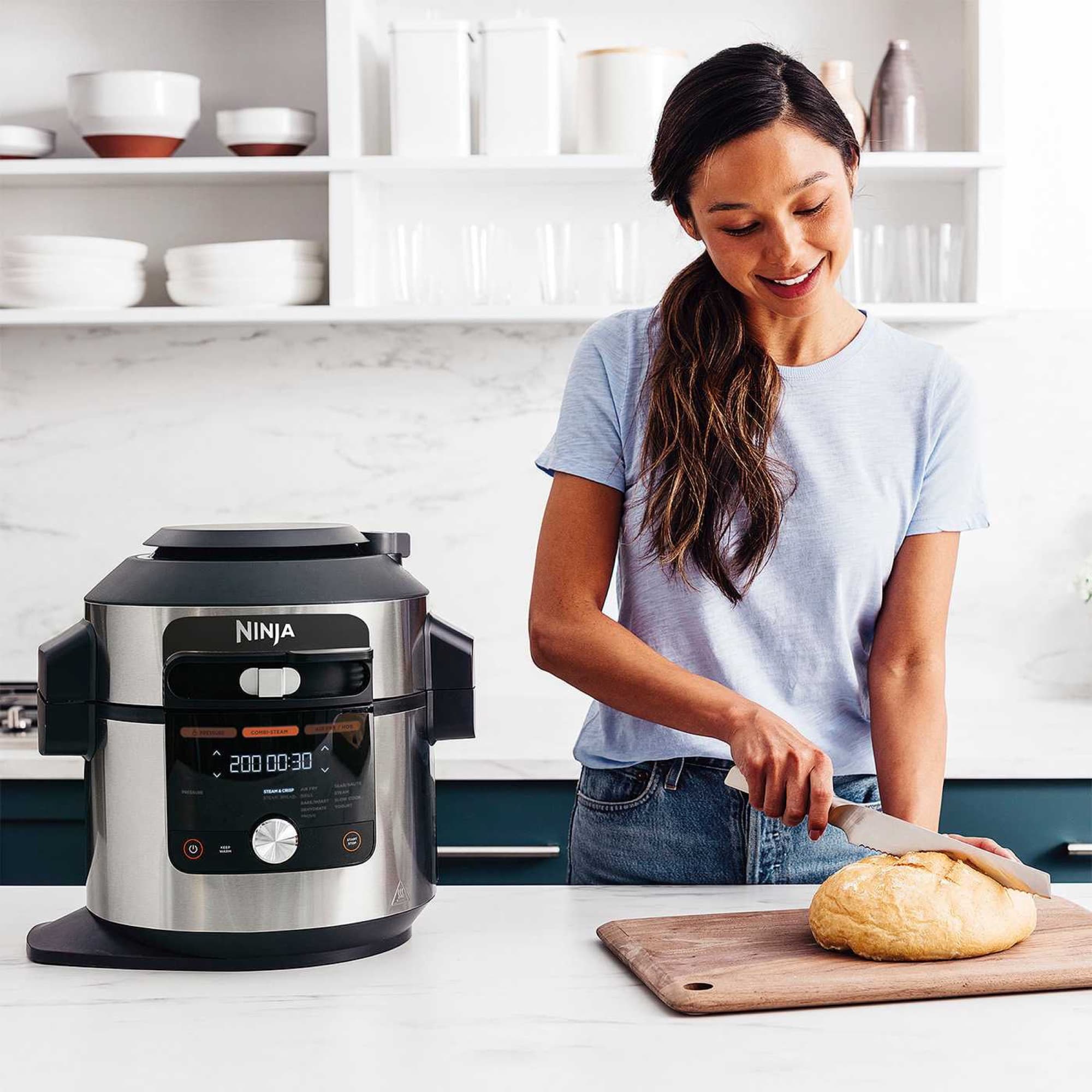 Freshly baked bread being sliced next to the appliance