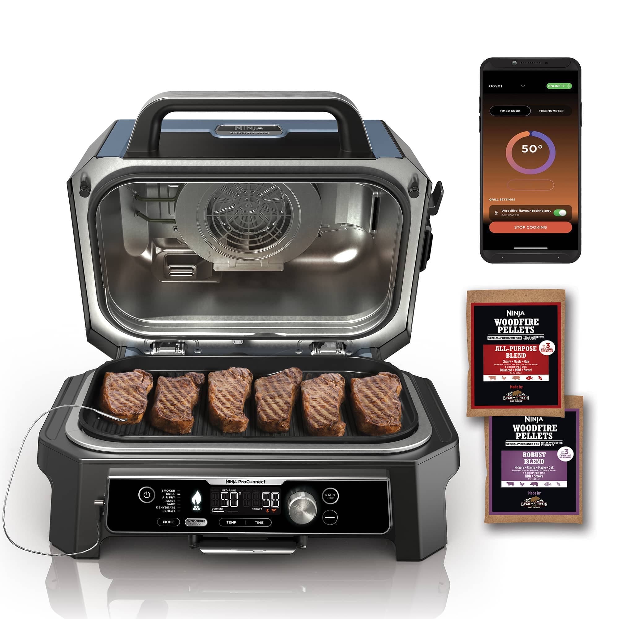 The grill open with steaks, the app and wood pellets