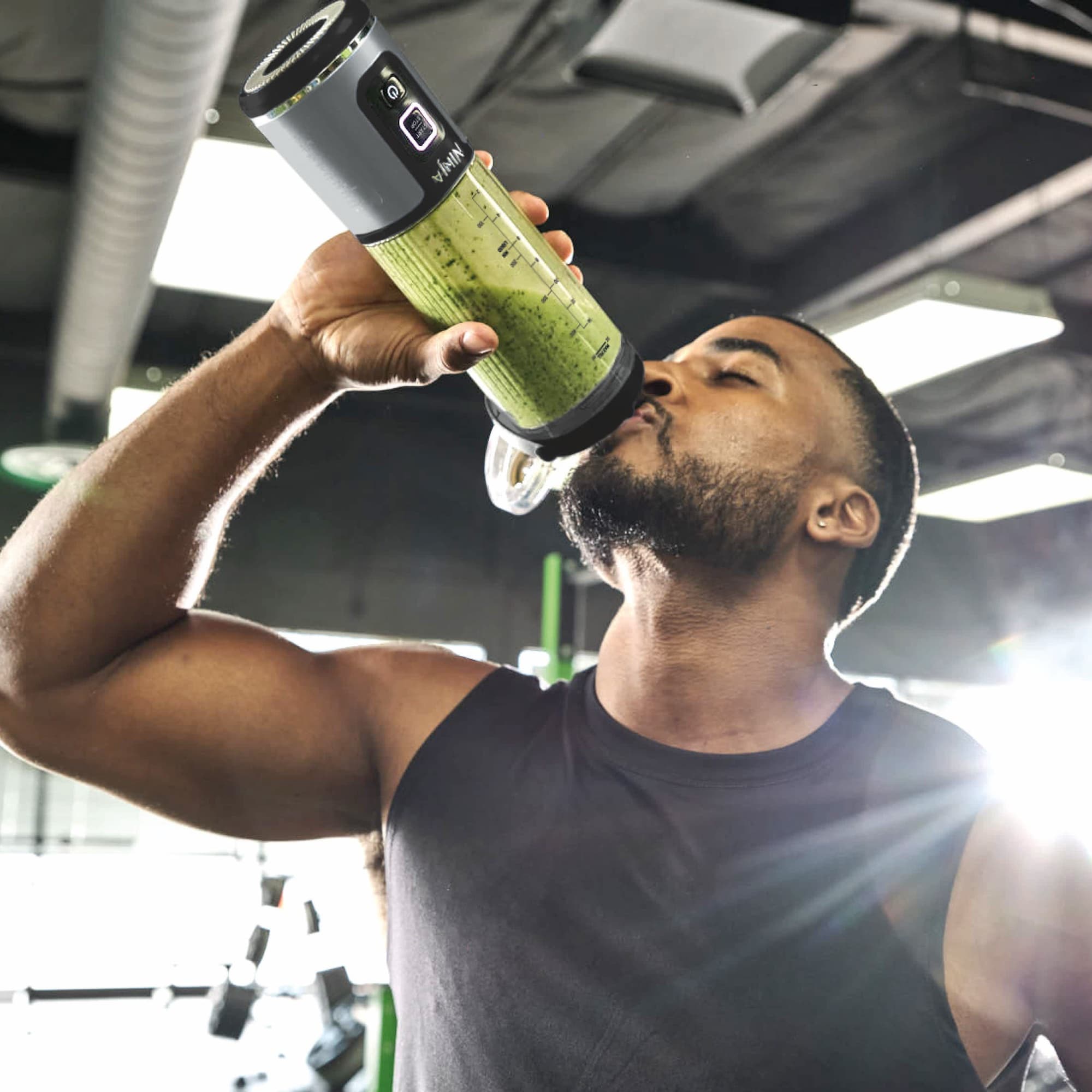Man drinking straight from the cup at the gym