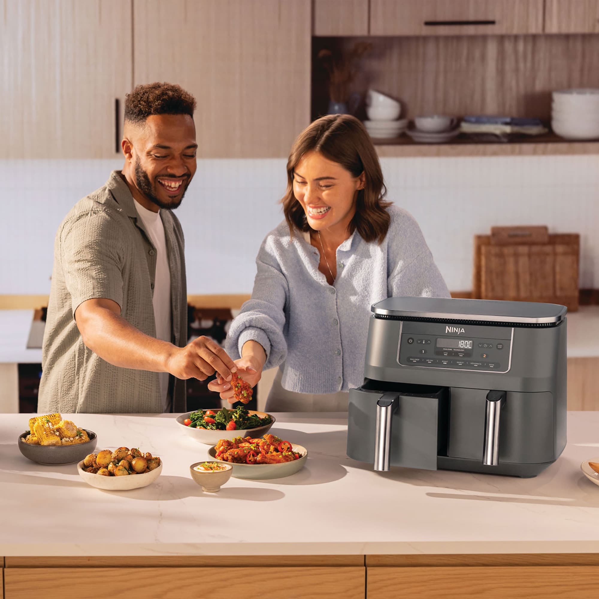 Couple serving food next to the air fryer