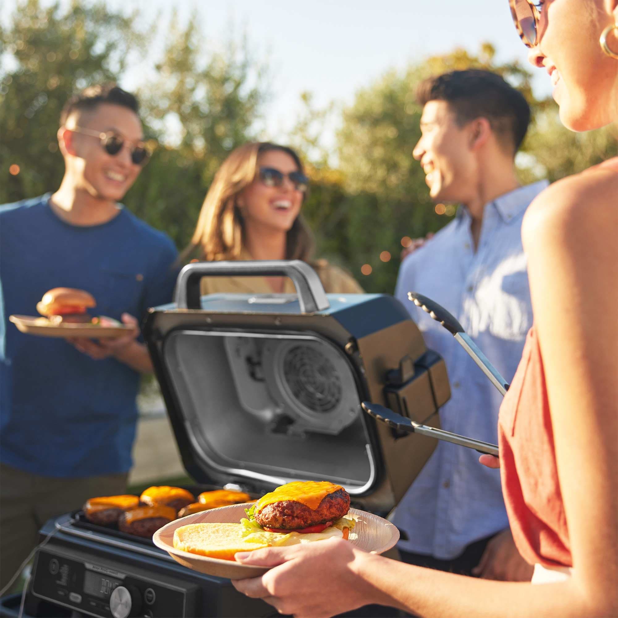 Friends grilling burgers in the garden