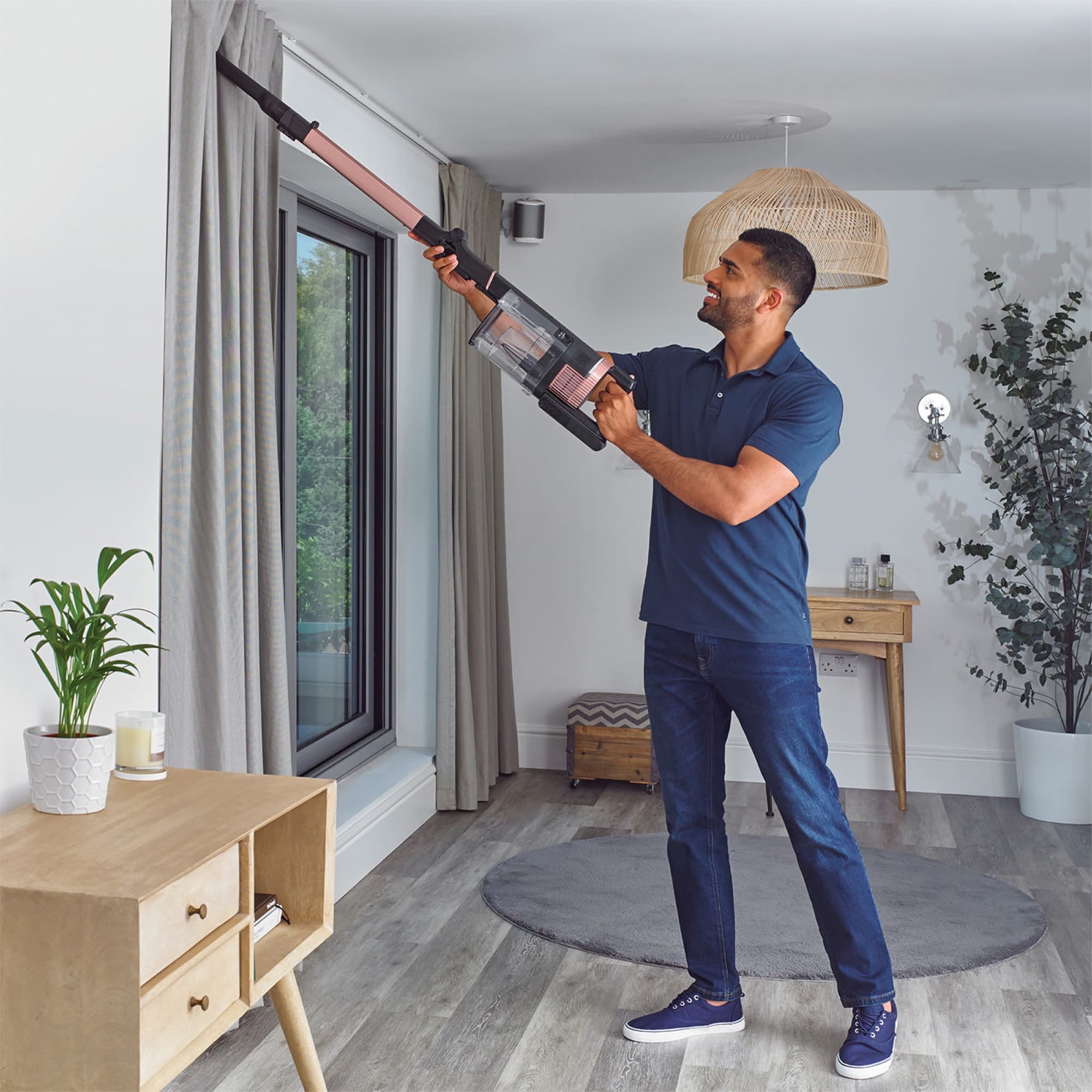 The wand pointed upwards to vacuum by the curtains