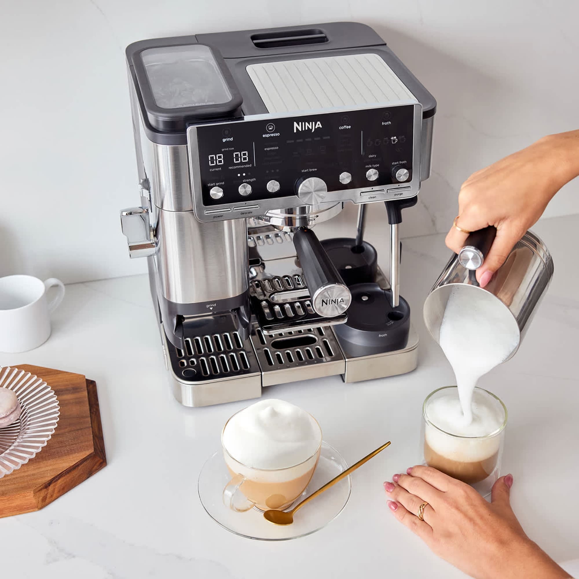 Frothed milk poured into a cup next to the machine