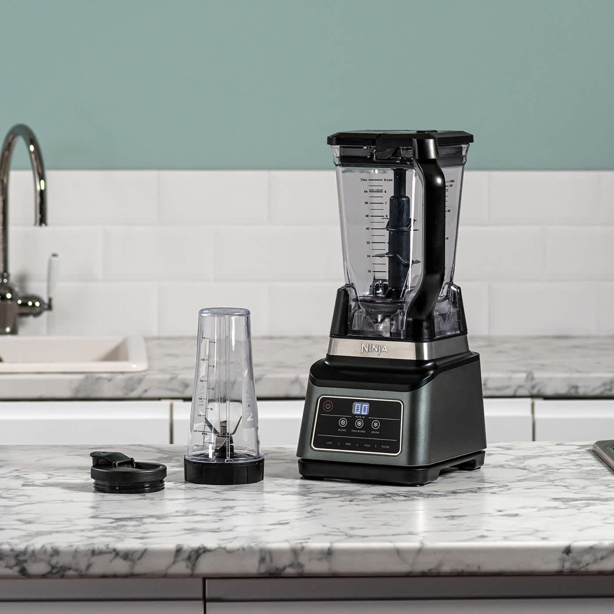 The blender on a worktop with the cup beside it