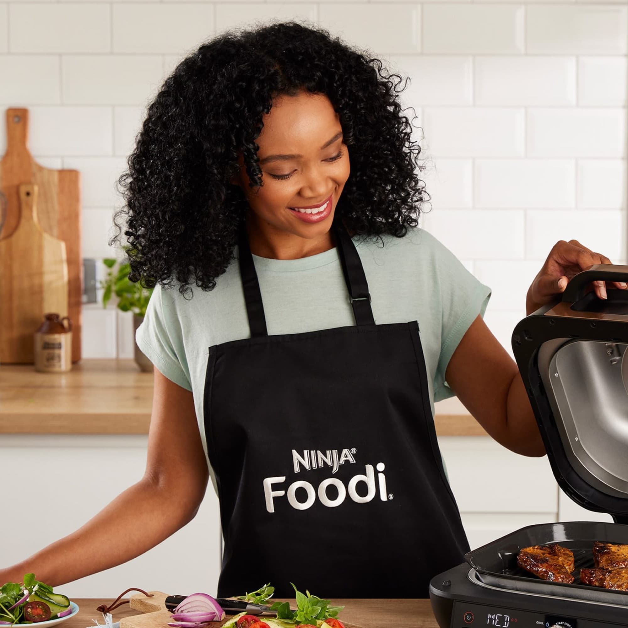 Woman in the apron at a Ninja air fryer