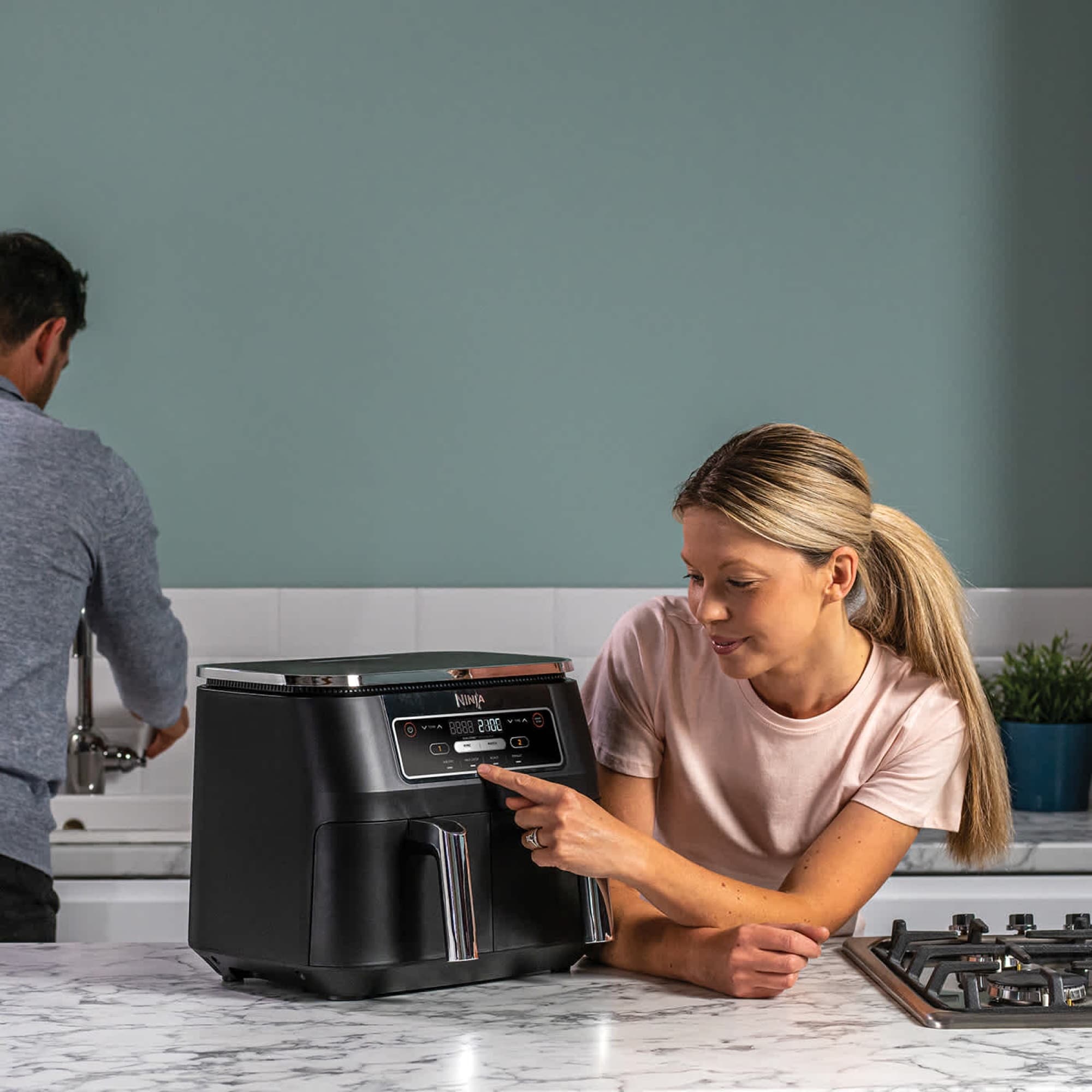Woman setting the air fryer on the kitchen worktop
