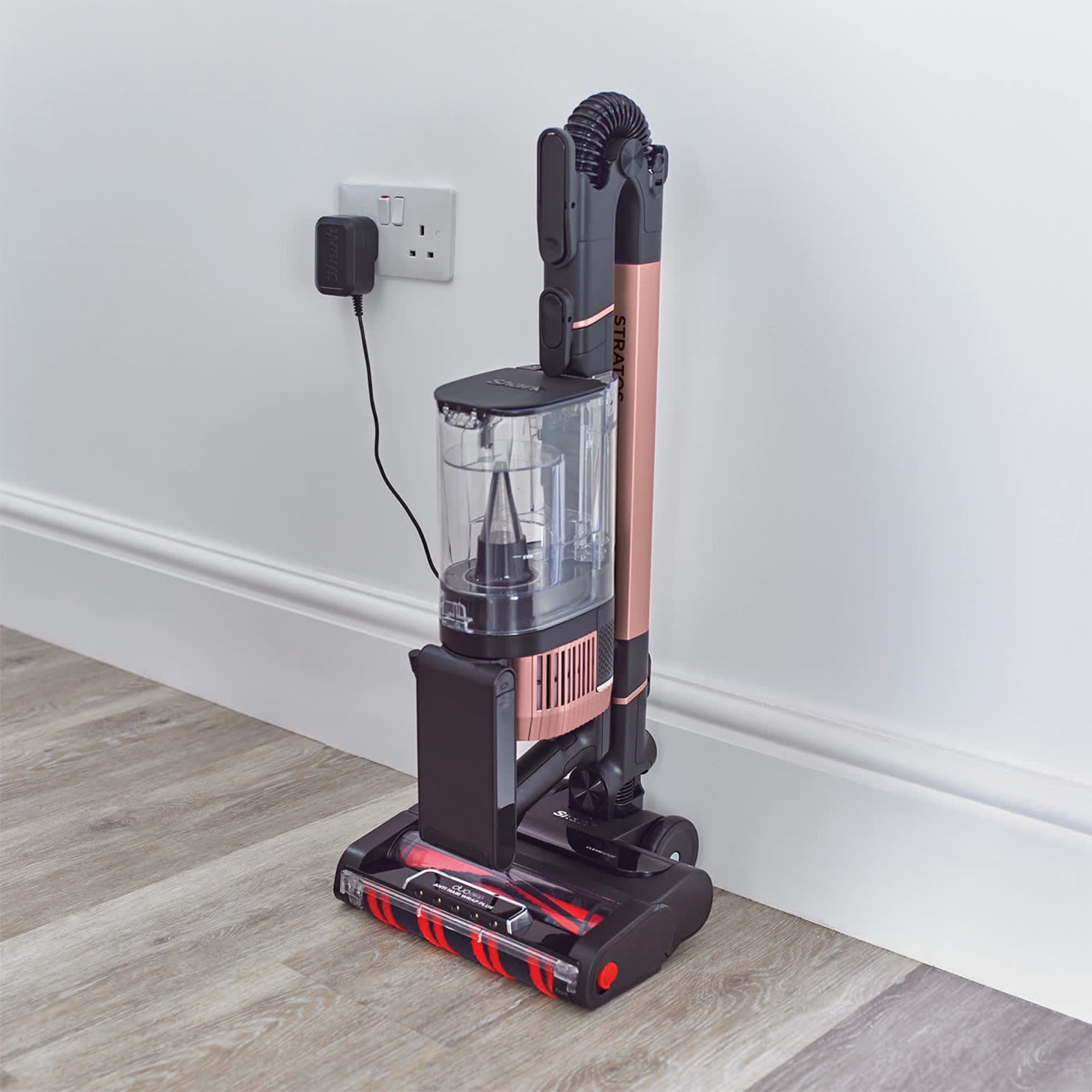 The vacuum stands folded by the wall, charging