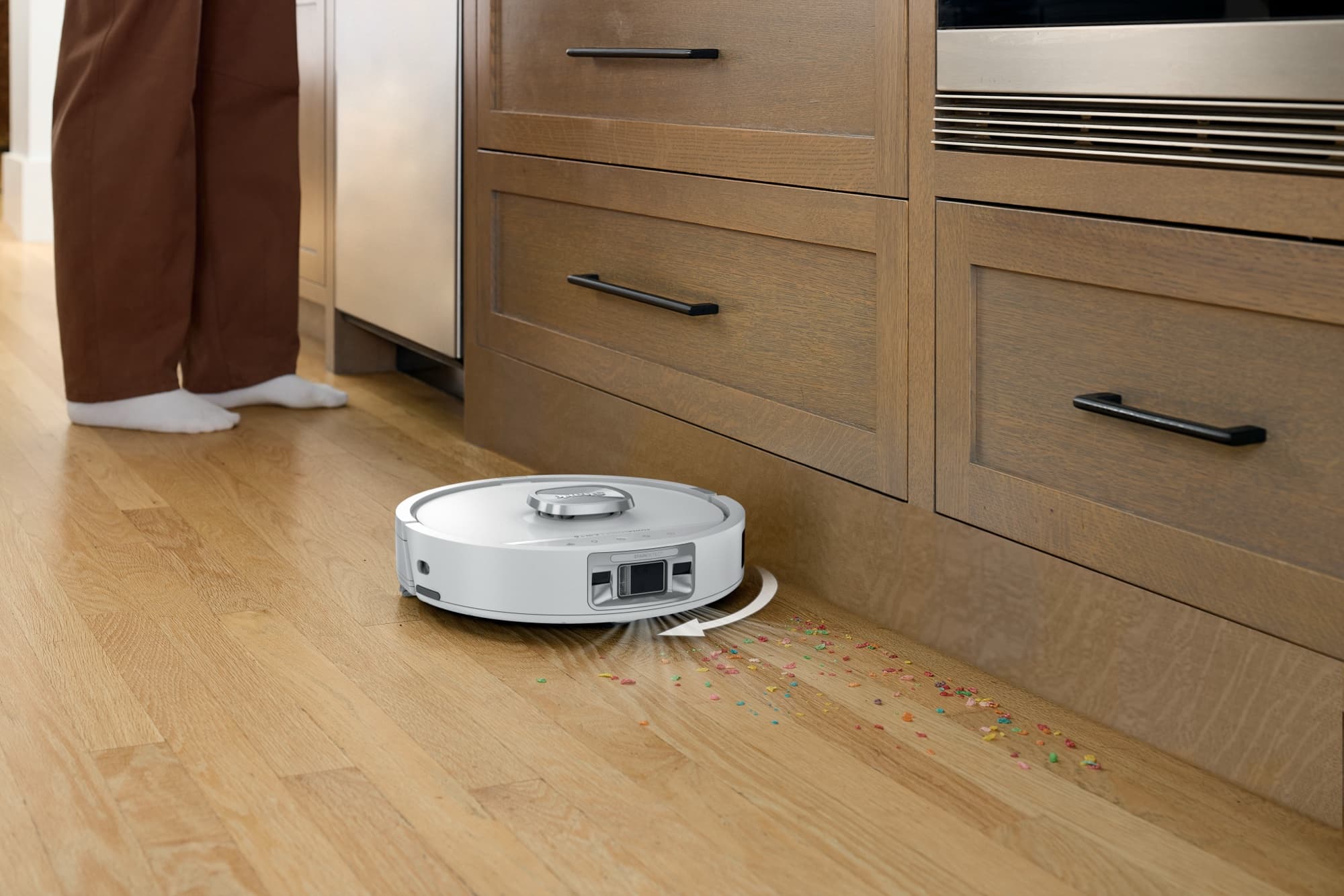 The robot cleaning the kitchen floor along the cupboards
