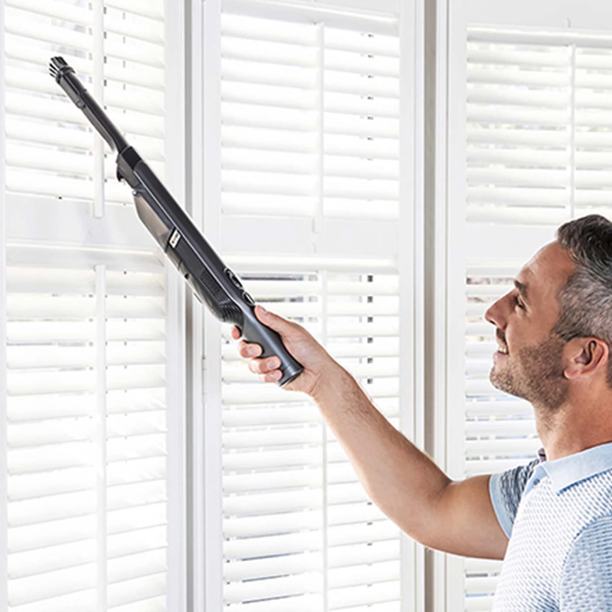 The handheld reaching up high by the blinds